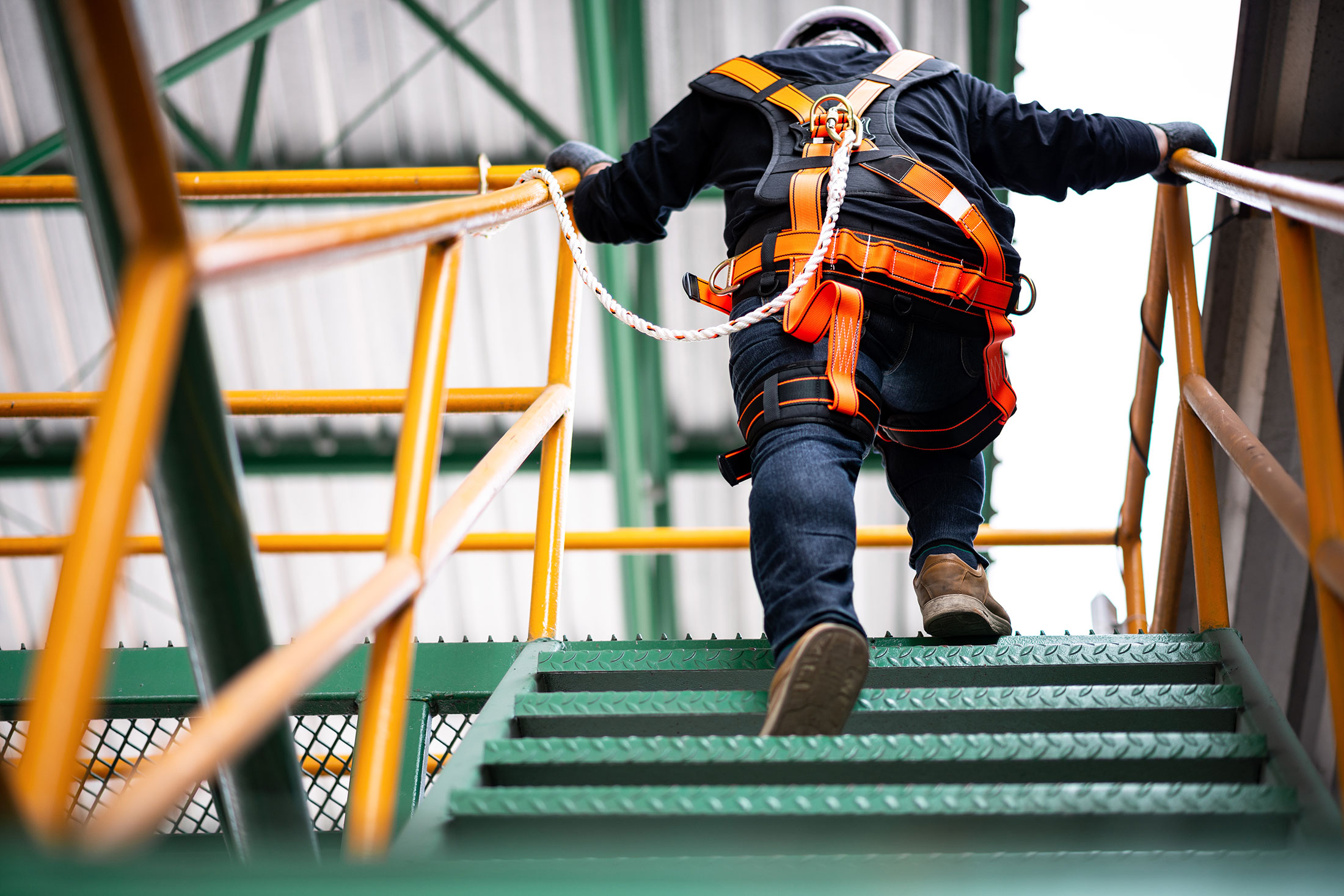 man in safety gear going up stairs